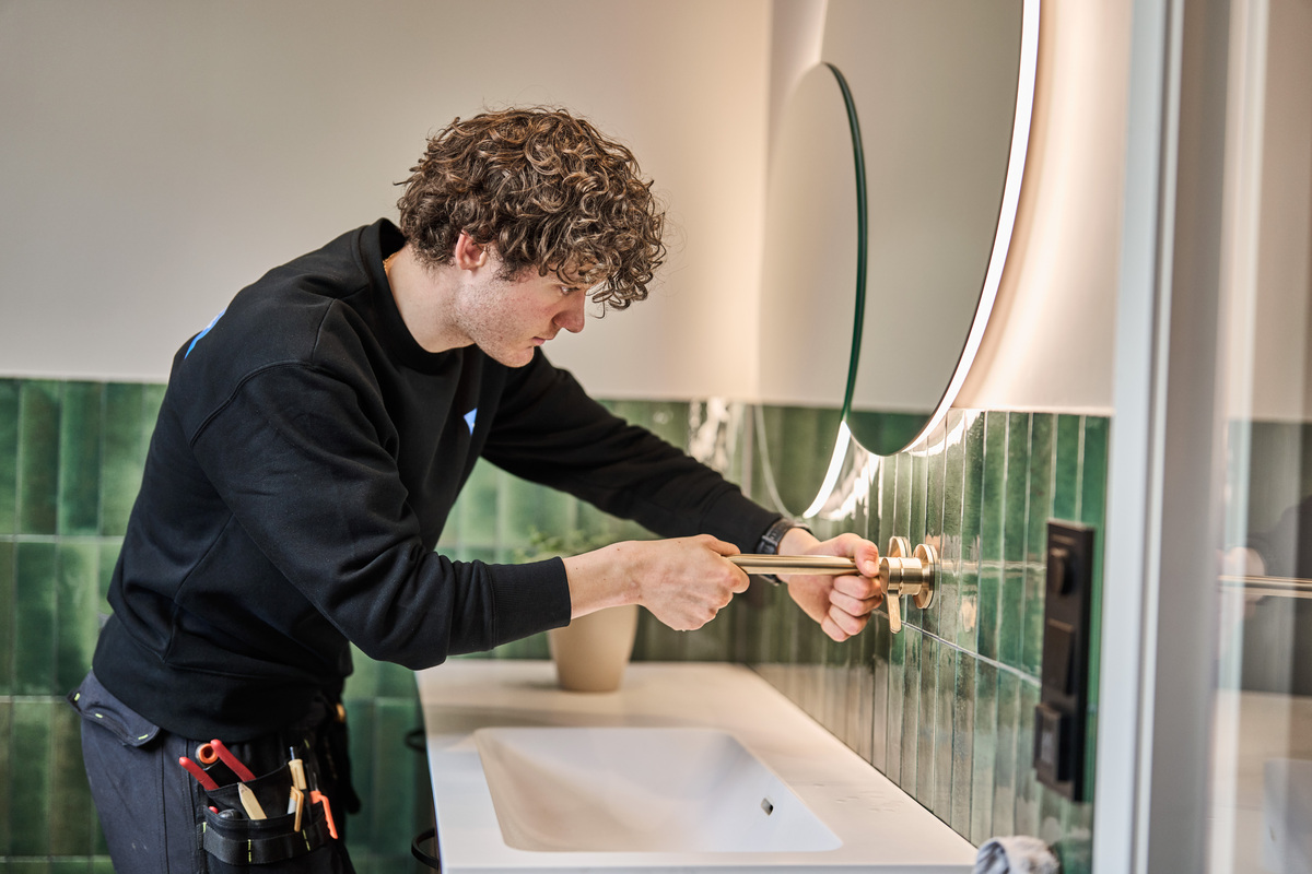 VB rørlegger skrur på plass servantarmatur på bad